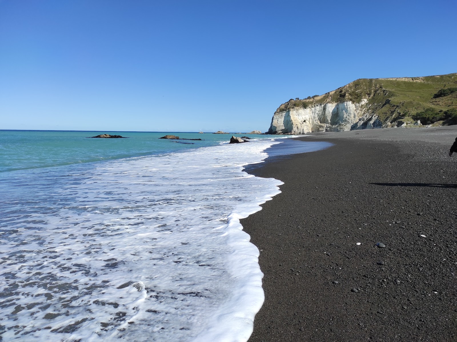 Fotografija Nape Nape Beach z sivi fini kamenček površino