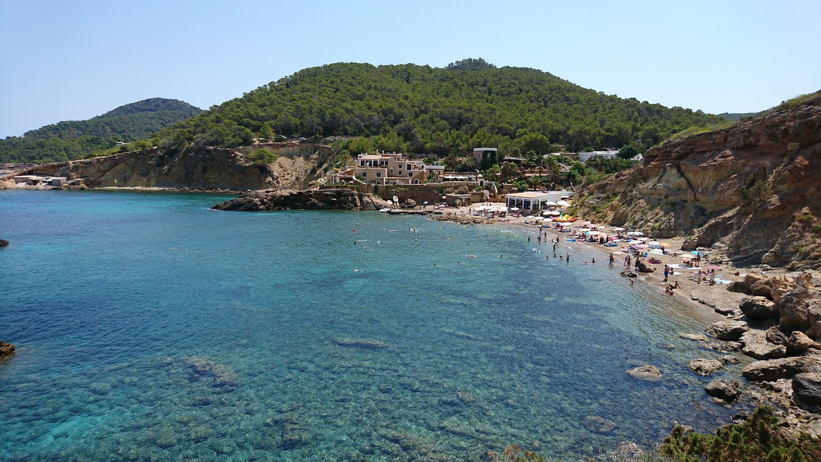 Valokuva Playa Cala Xarracaista. pinnalla harmaa hiekka ja kivet:n kanssa