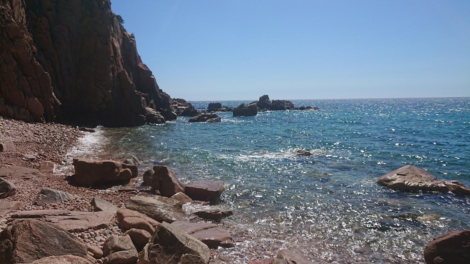 Foto van Punta d'Aromir met helder zand & rotsen oppervlakte