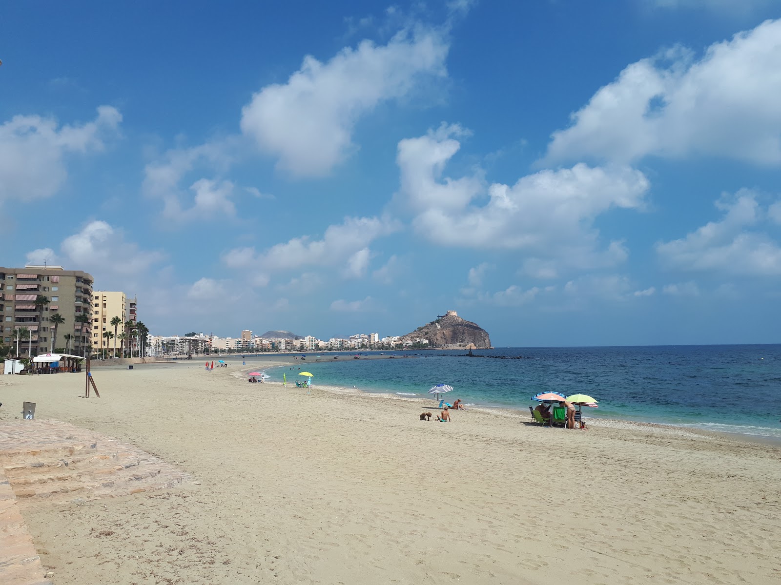 Foto av Playa de Poniente med små bruna småstenar yta