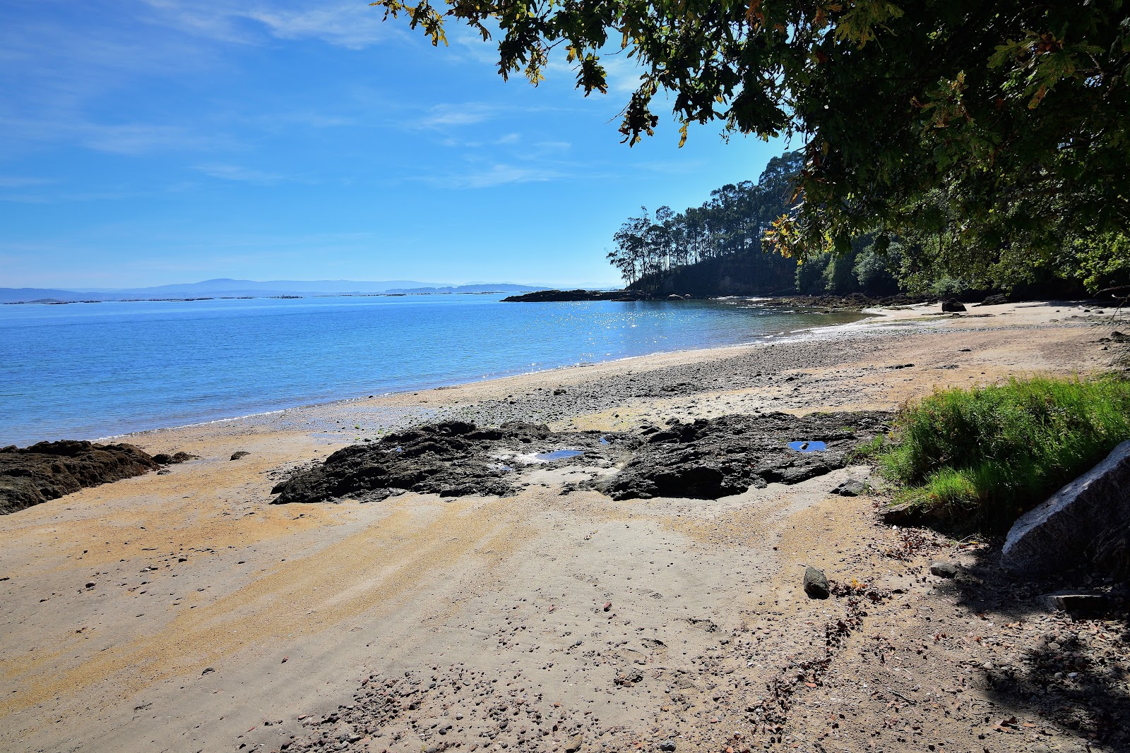 Zdjęcie Praia Da Merce z powierzchnią beżowy piasek i kamienie