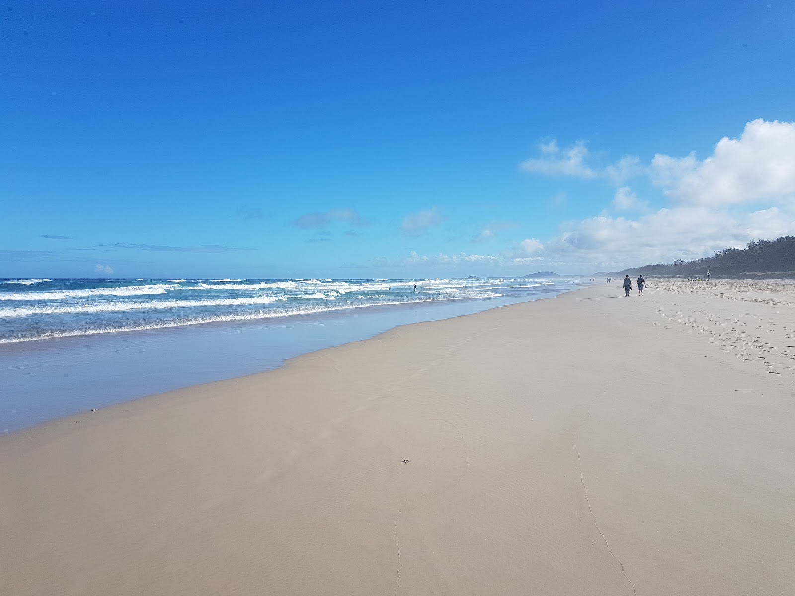Foto de Casuarina Beach con recta y larga