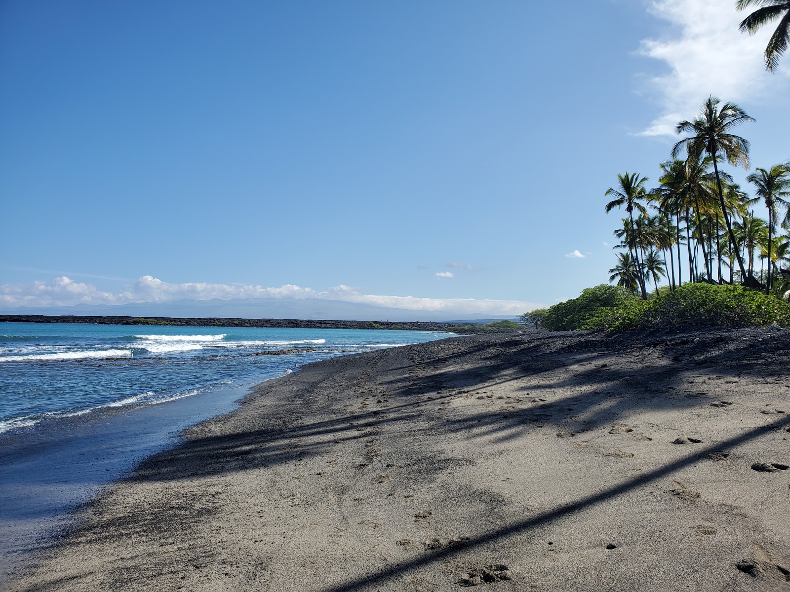 Foto av Kiholo Bay Beach med grå sten yta