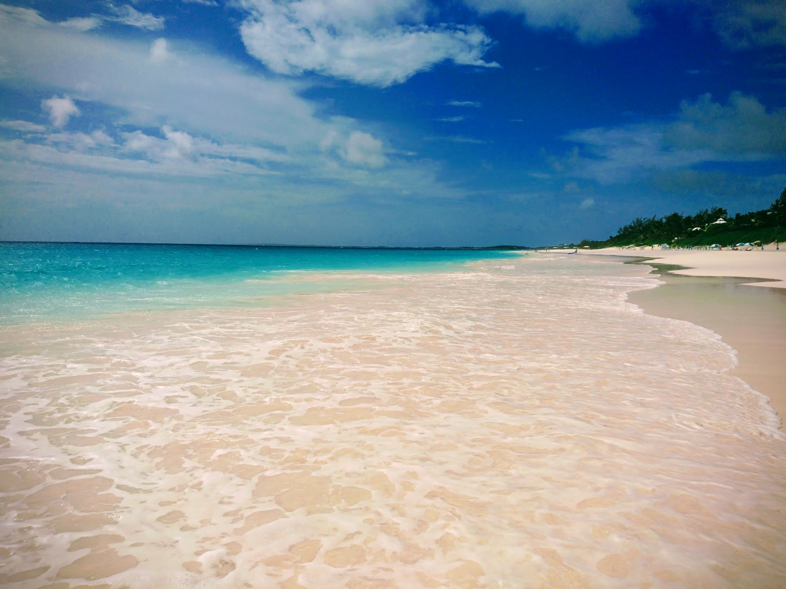 Valokuva Vaaleanpunainen hiekka Rantaista. pinnalla turkoosi puhdas vesi:n kanssa