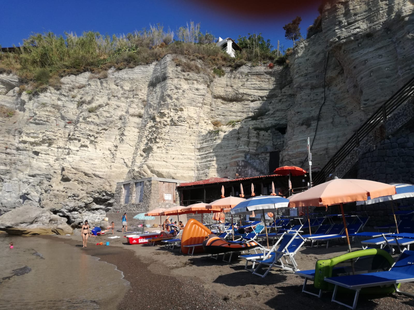 Foto af Spiaggia di Cava Grado bakket op af klipperne