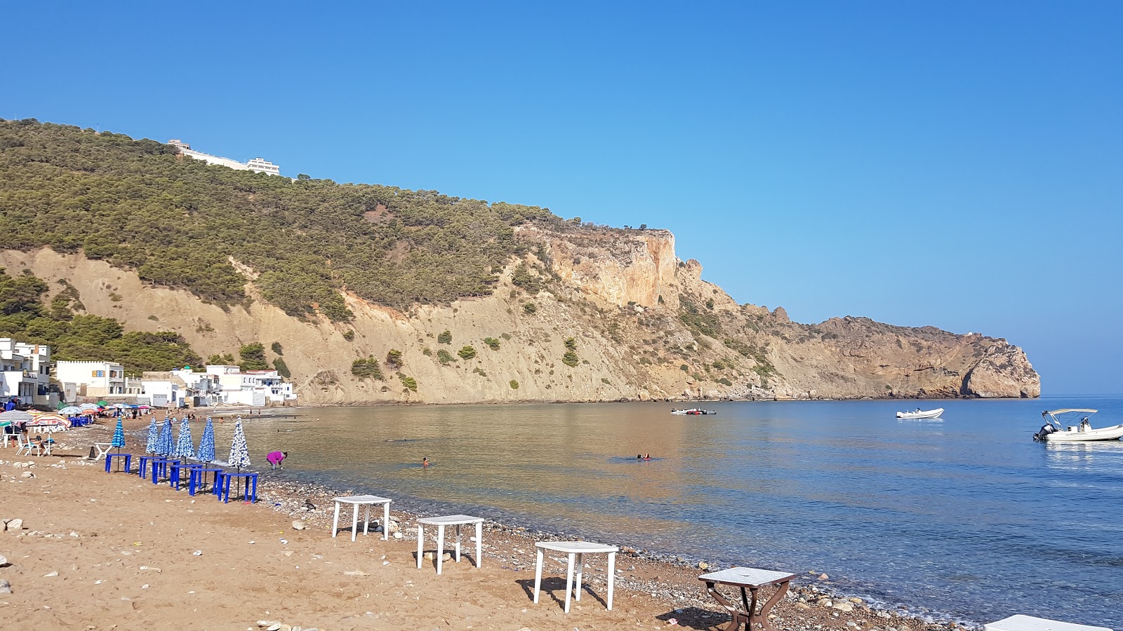 Foto av Plage Sidna Youchaa med ljus sand och stenar yta