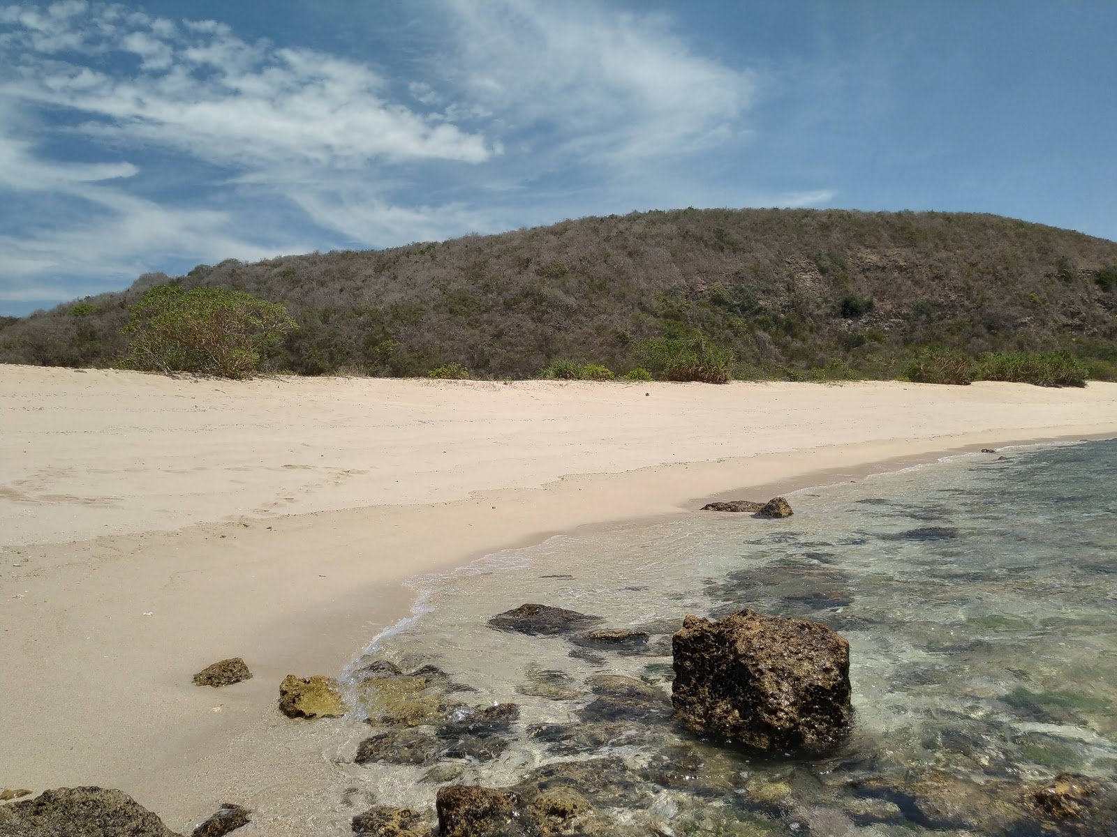 Teluk Ujung Beach'in fotoğrafı uçurumlarla desteklenmiş