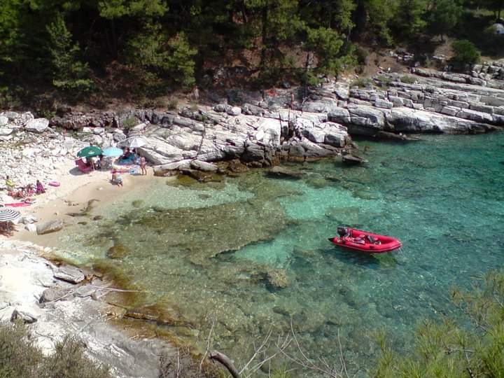 Foto de Skidia beach con arena beige y rocas superficie