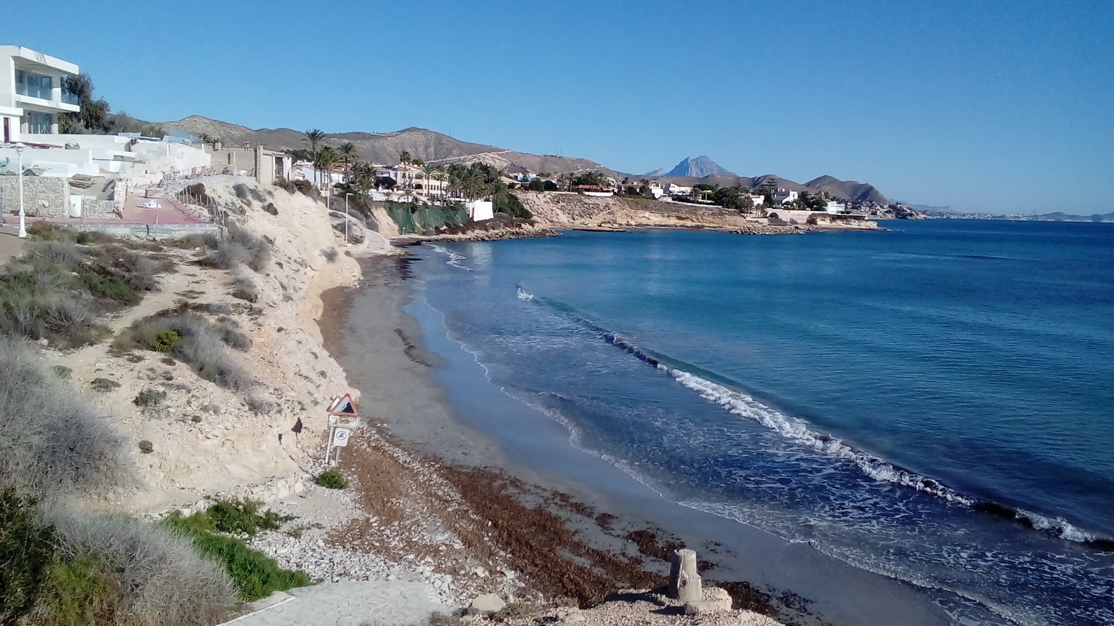 Platja de l'Almadrava'in fotoğrafı dağlarla çevrili