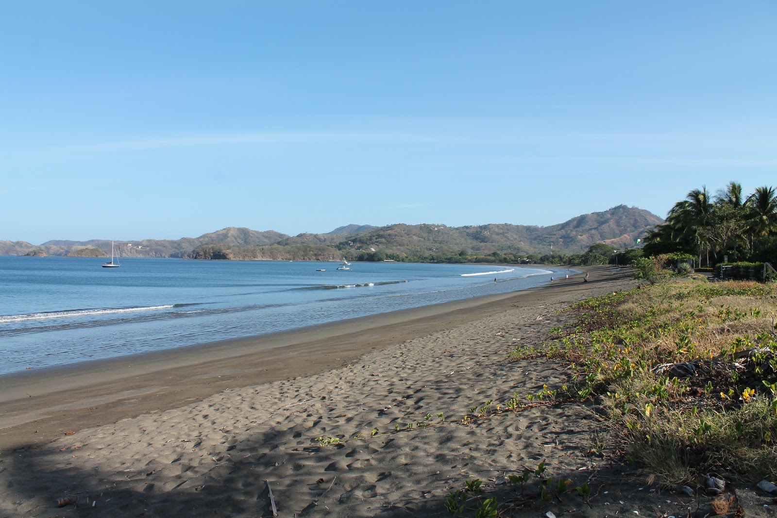 Foto di Potrero Beach con una superficie del sabbia grigia