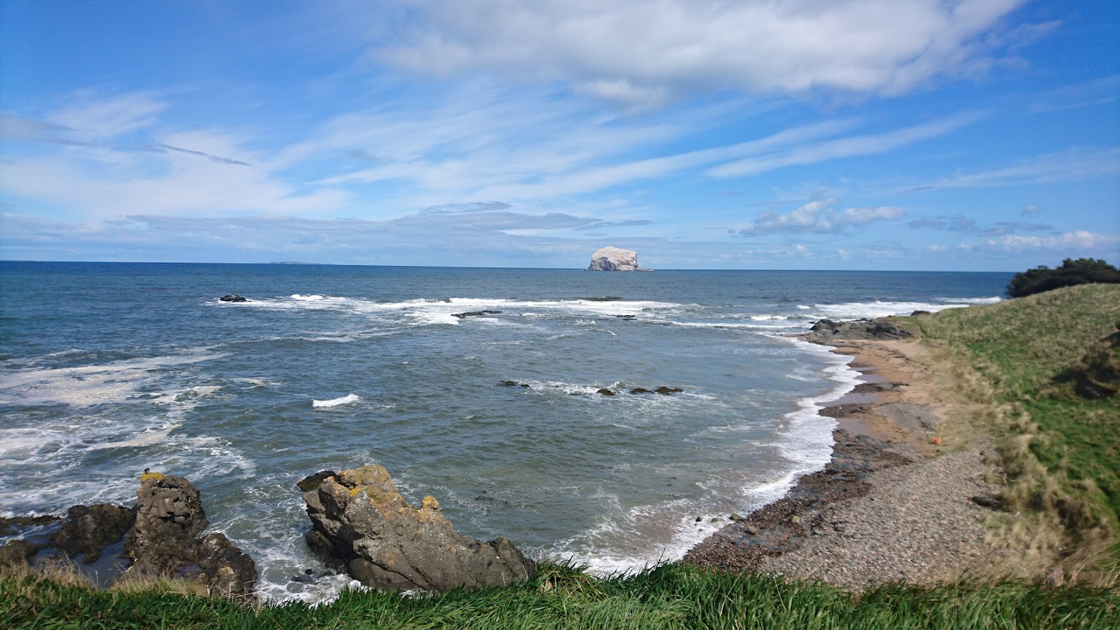 Foto di Haugh Road Beach con una superficie del sabbia beige e rocce