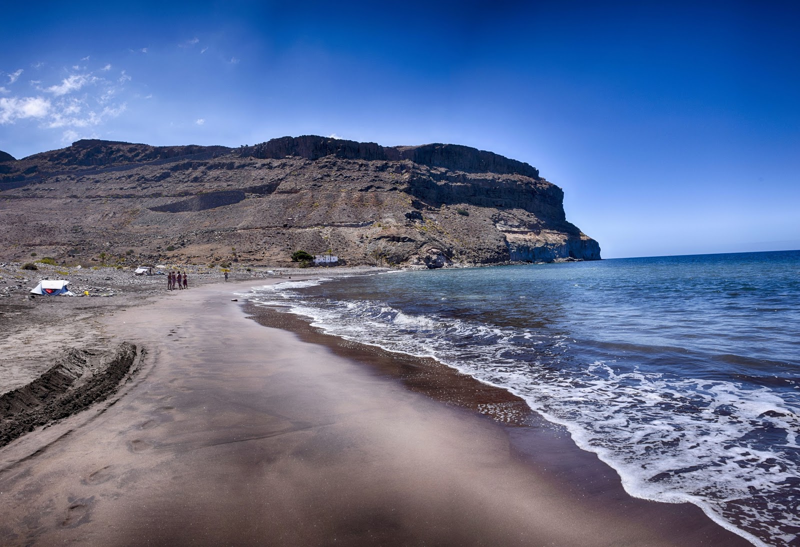 Photo de Playa de Veneguera avec sable gris avec caillou de surface