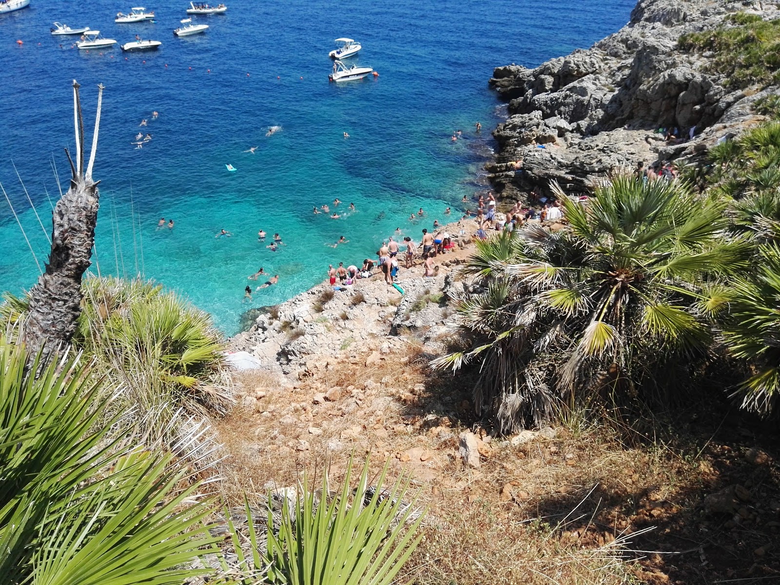 Foto av Cala Marinella med turkos rent vatten yta