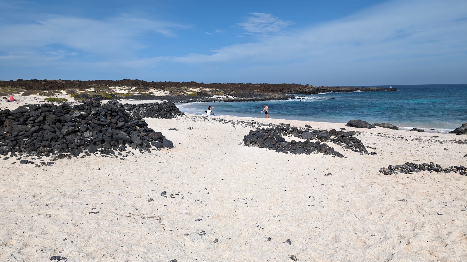 Foto av Caleta del Mojon med beige sand och stenar yta