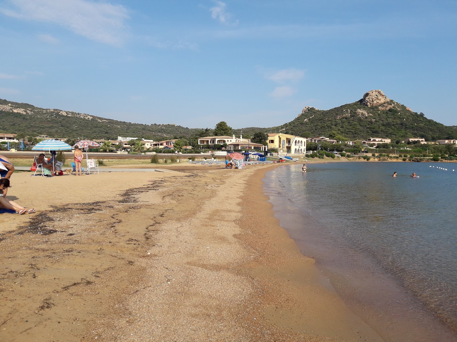 Foto von Cannigione Strand von Klippen umgeben
