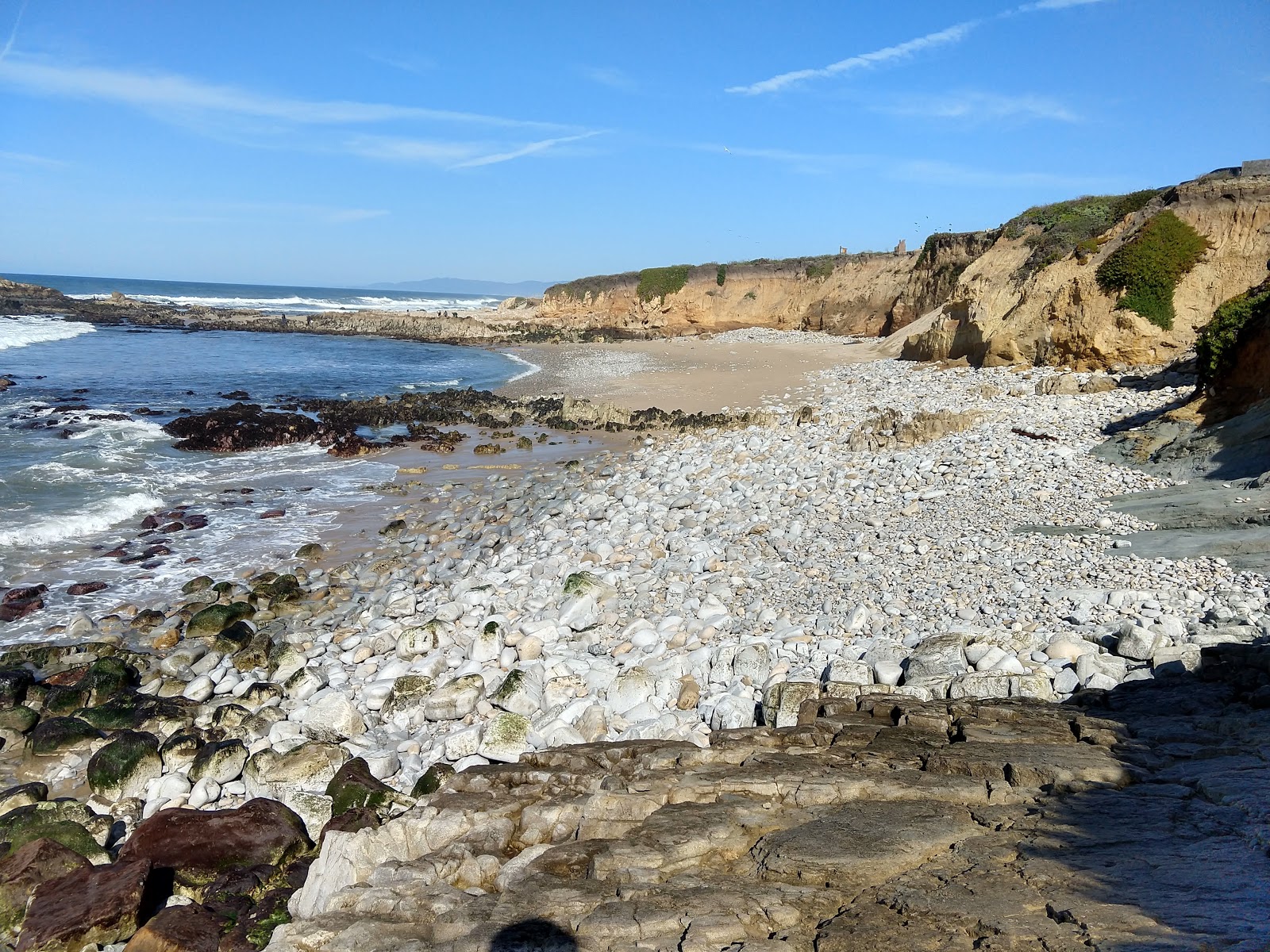 Foto de Pescadero Beach con arena brillante y rocas superficie