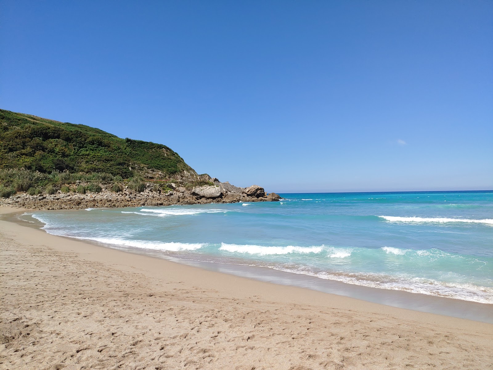 Valokuva Playa de Usgoista. pinnalla turkoosi puhdas vesi:n kanssa