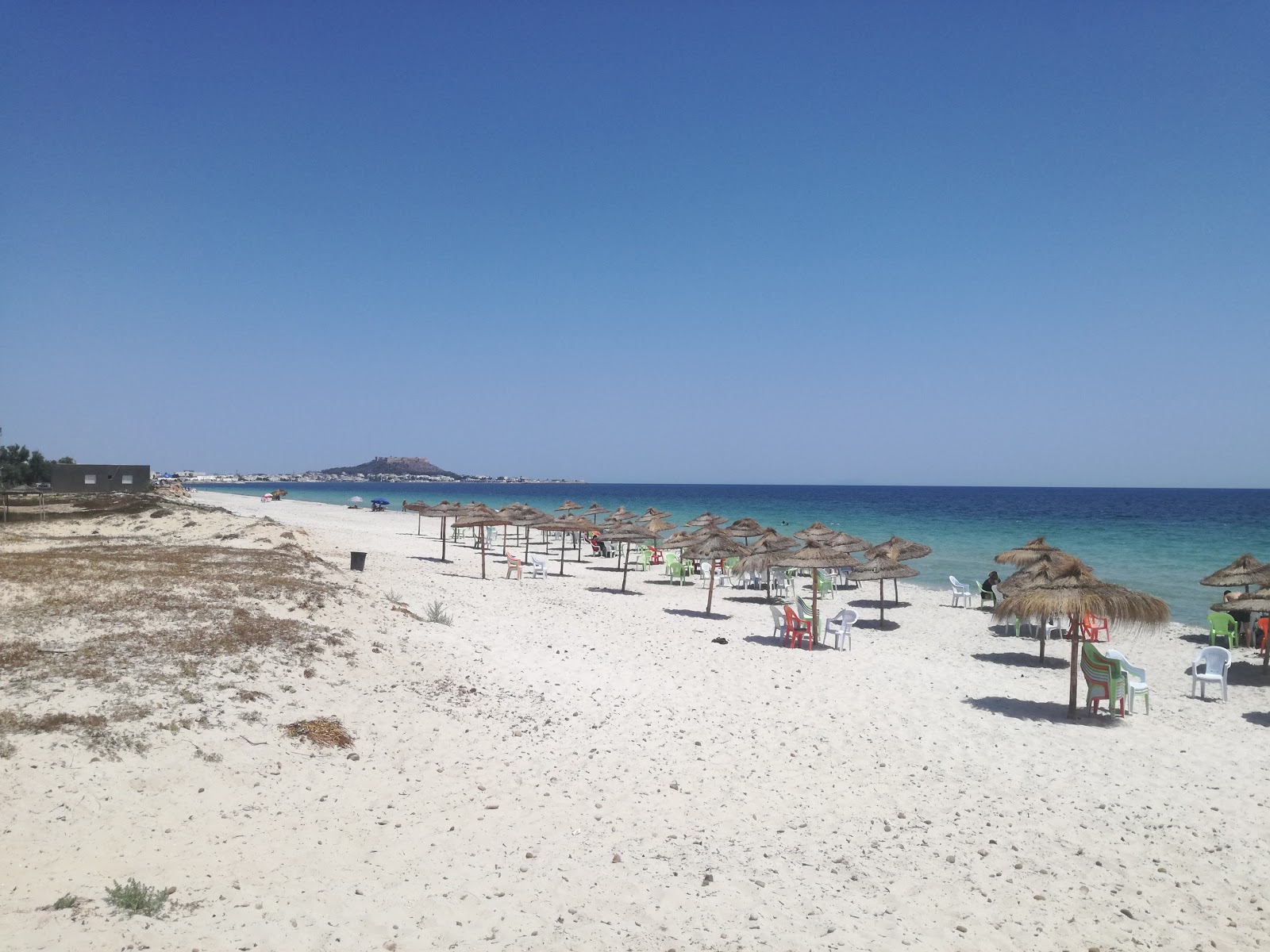 Foto von Ain Grenz Beach mit feiner beiger sand Oberfläche