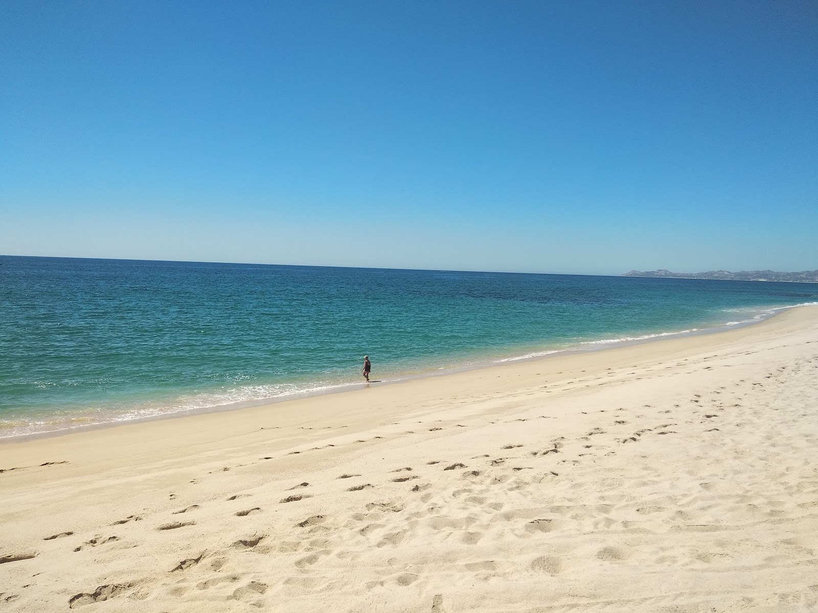 Fotografija East Cape Beach z svetel fin pesek površino