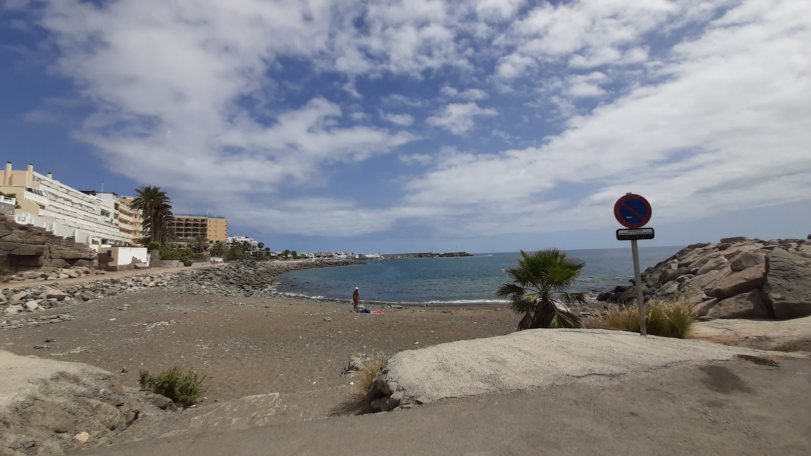 Foto av Playa La Carrera med musta hiekka ja kivi yta