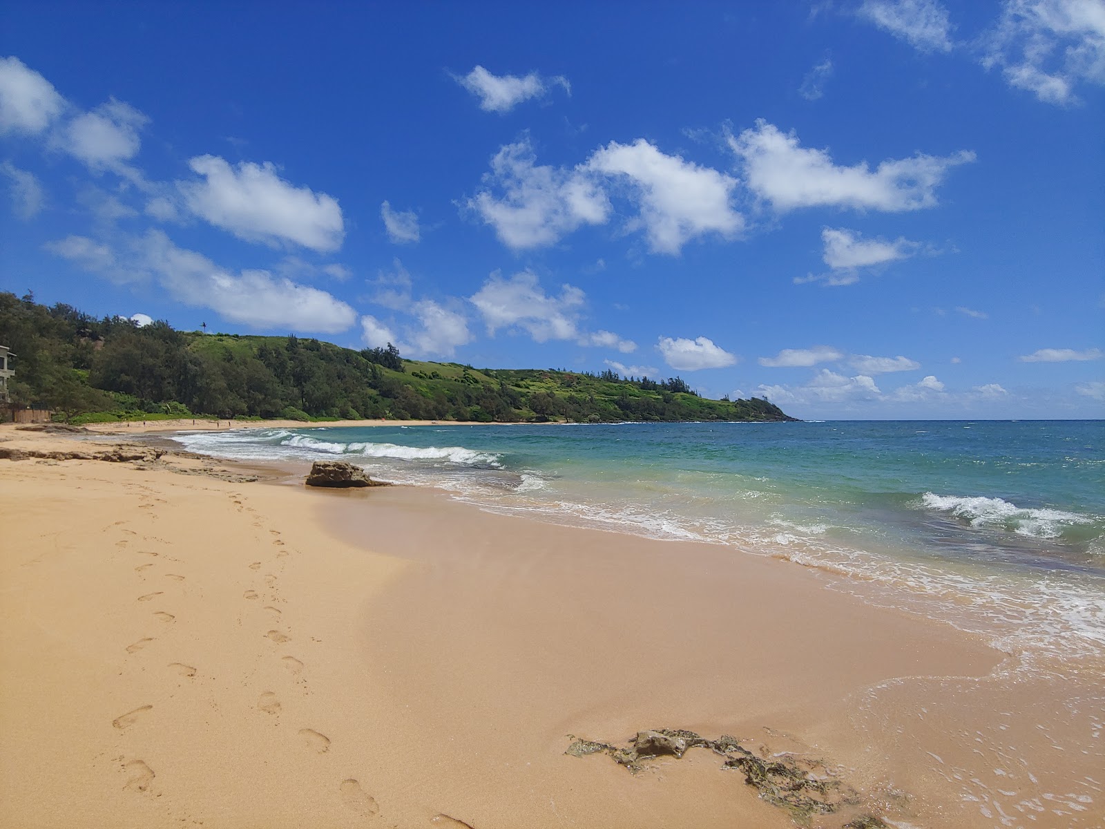 Foto de Moloa'a Beach com areia brilhante superfície