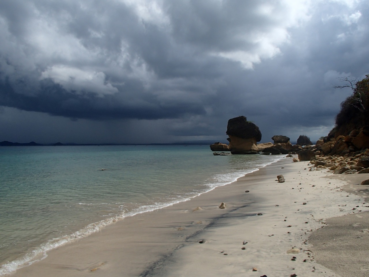 Foto van Batu Jamur Beach omringd door bergen