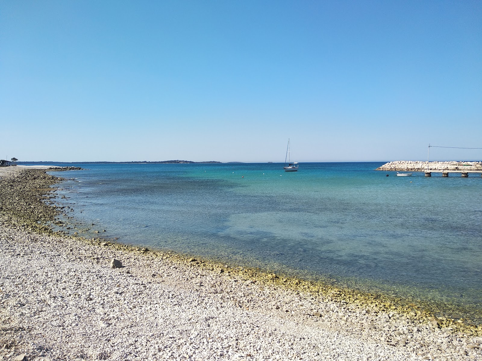 Foto von Portic beach mit türkisfarbenes wasser Oberfläche