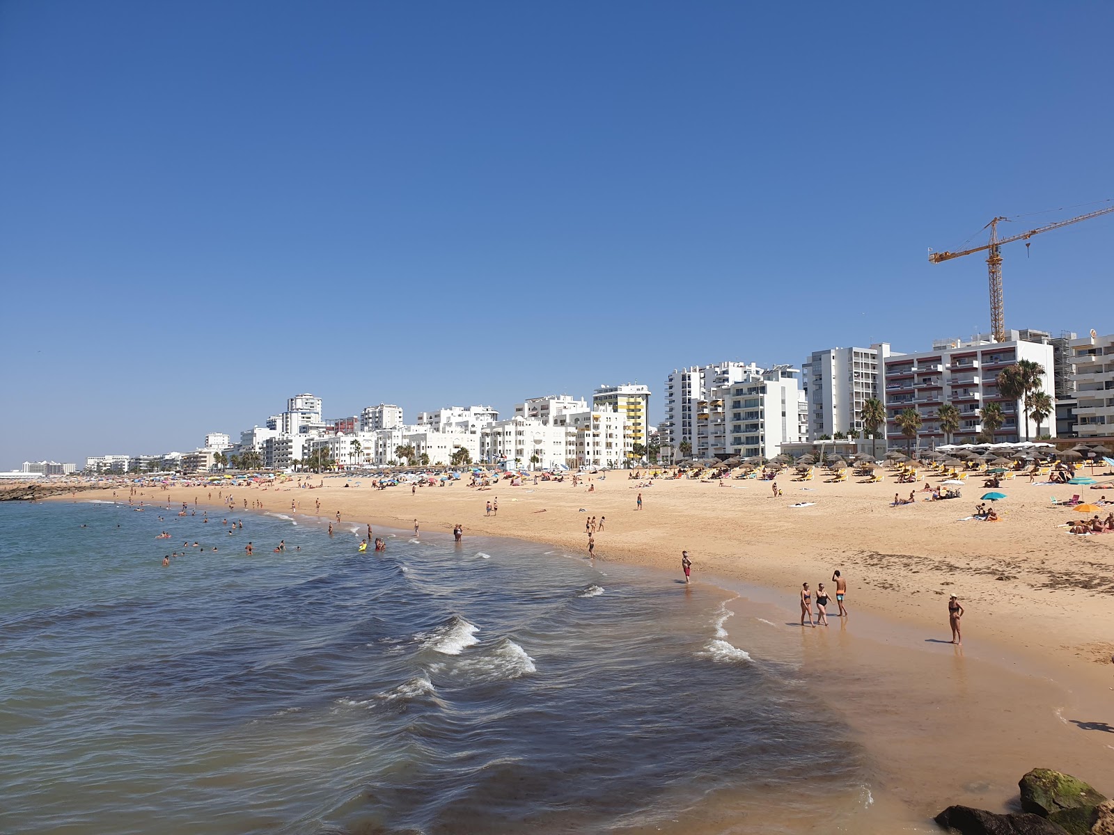 Foto di Praia de Quarteira con una superficie del sabbia marrone