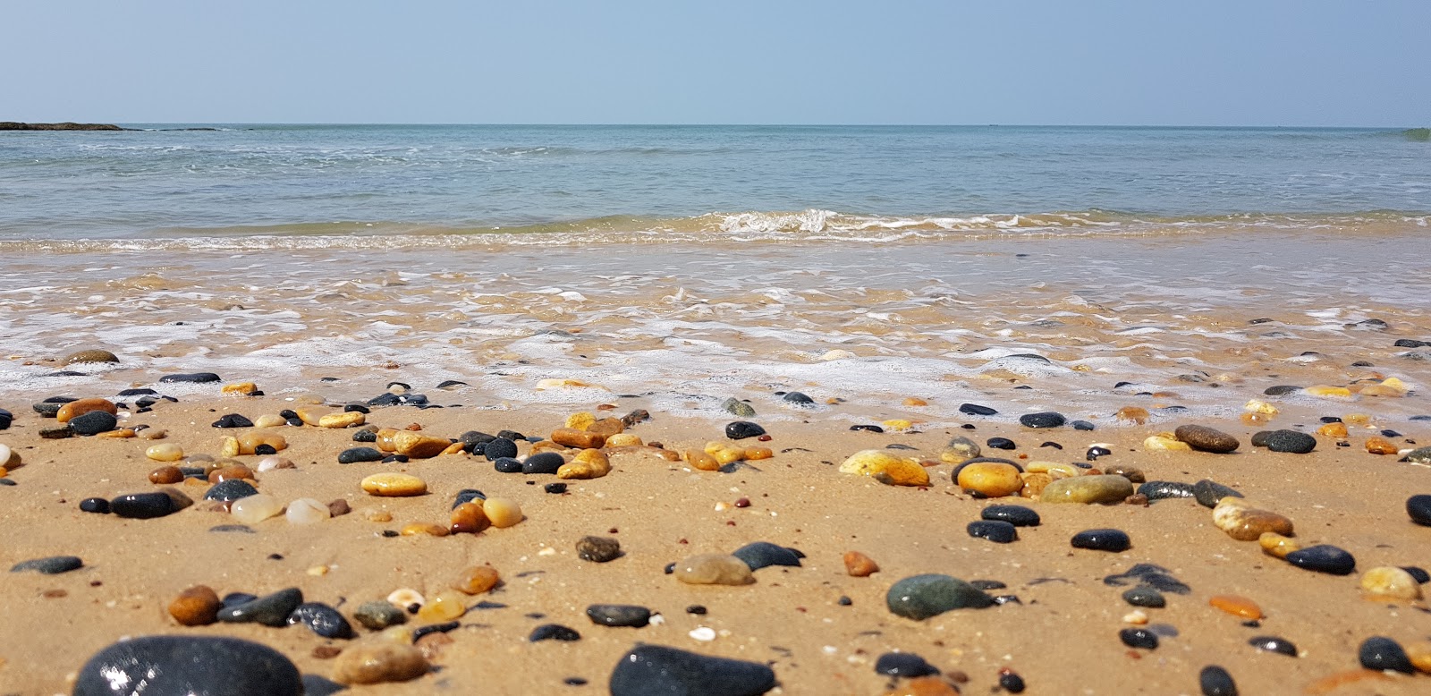 Foto av Belambar Beach med turkos rent vatten yta