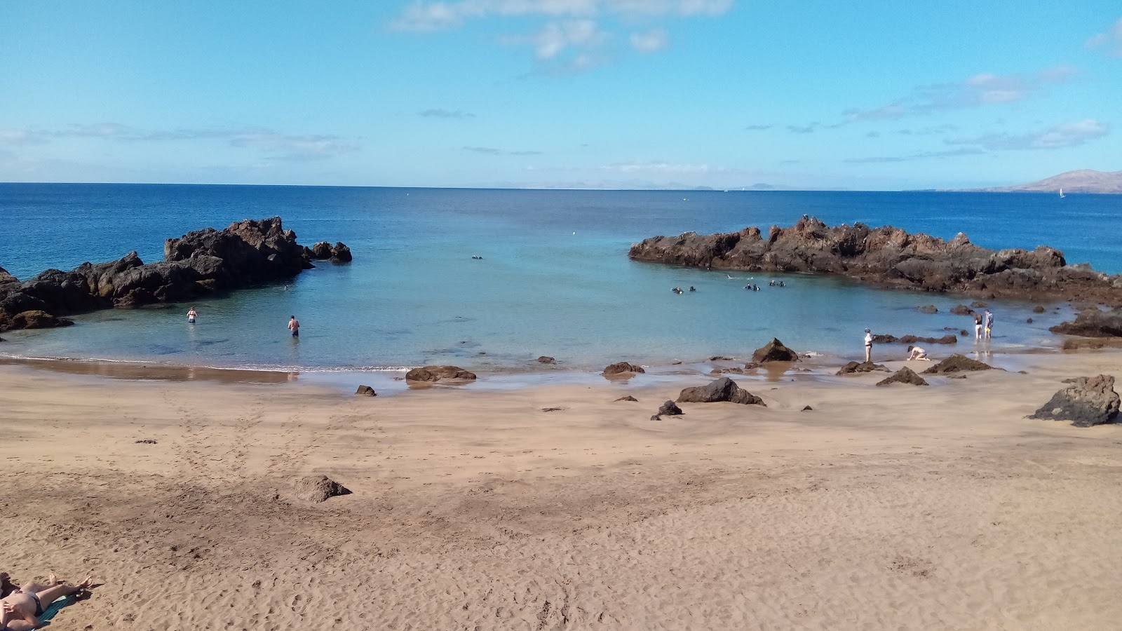 Fotografie cu Plaja Playa Chica cu o suprafață de apa pură turcoaz