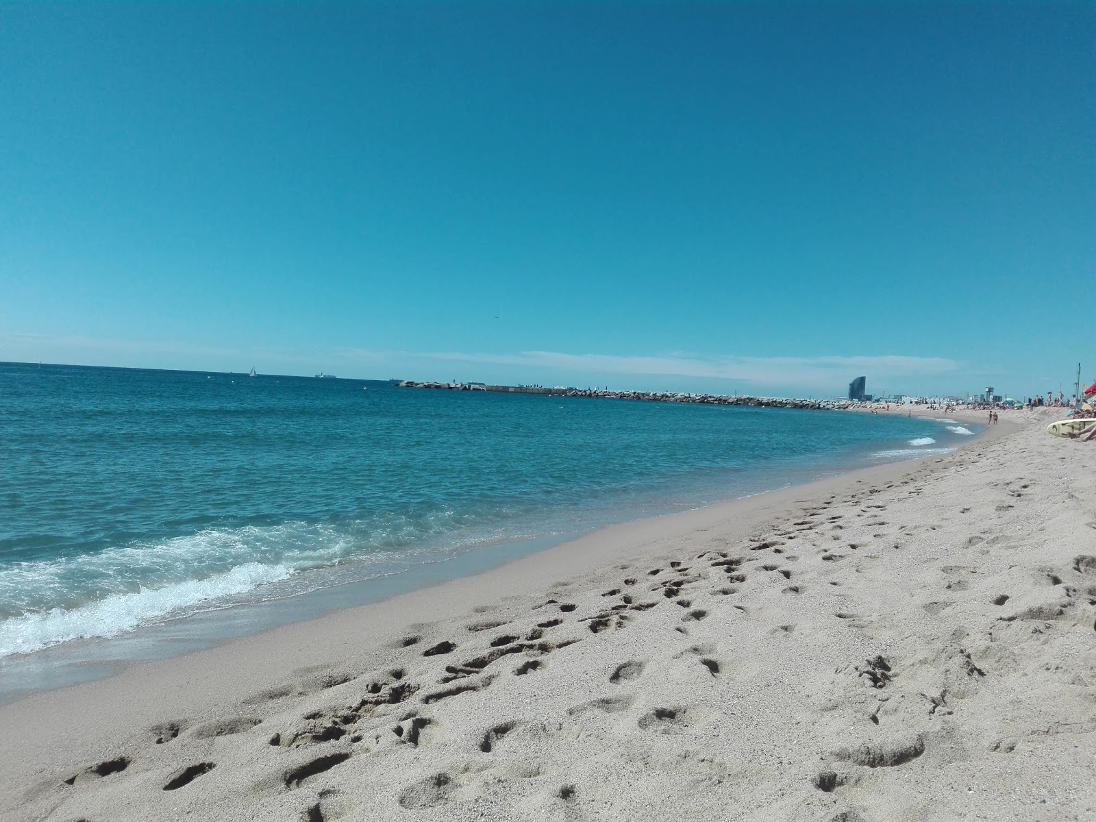 Platja de la Mar Bella'in fotoğrafı parlak ince kum yüzey ile