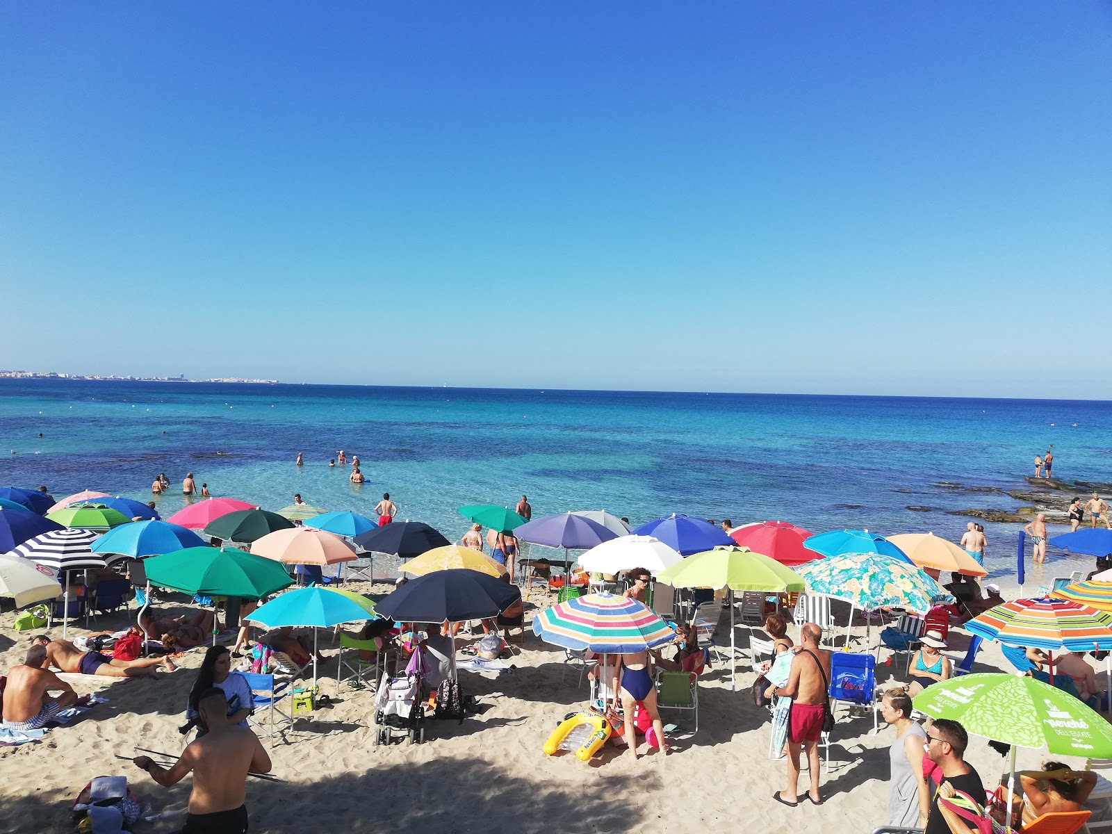 Valokuva Spiaggia di Lido Conchiglieista. pinnalla sininen puhdas vesi:n kanssa
