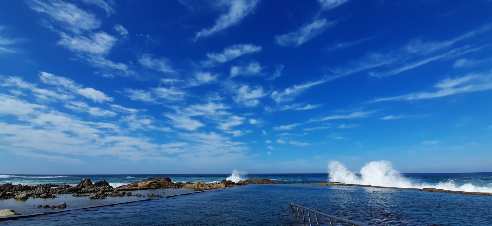 Manaba beach的照片 带有米色沙子表面