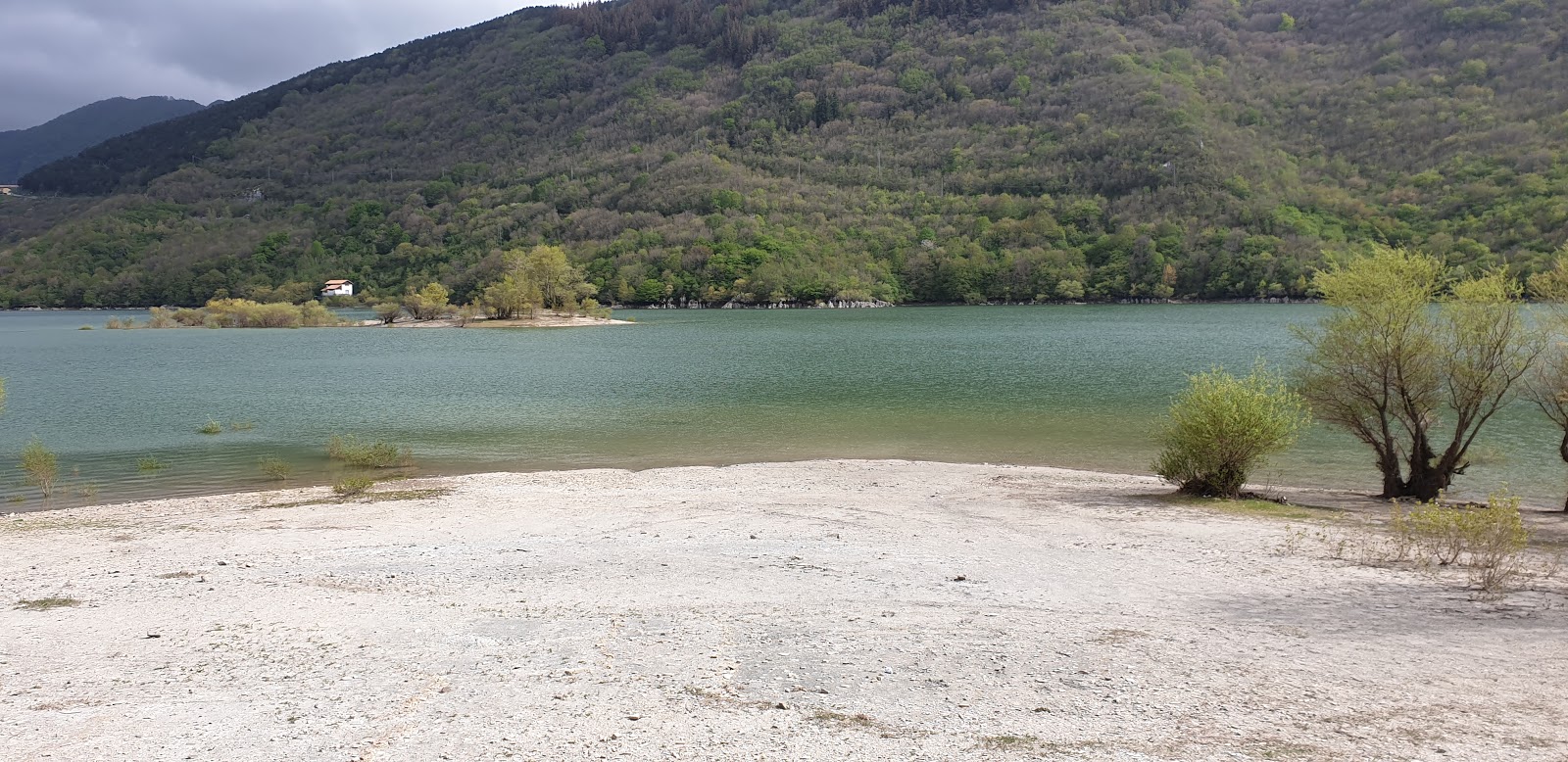 Fotografie cu Spiaggia de Lago di Gallo cu o suprafață de apa pură turcoaz