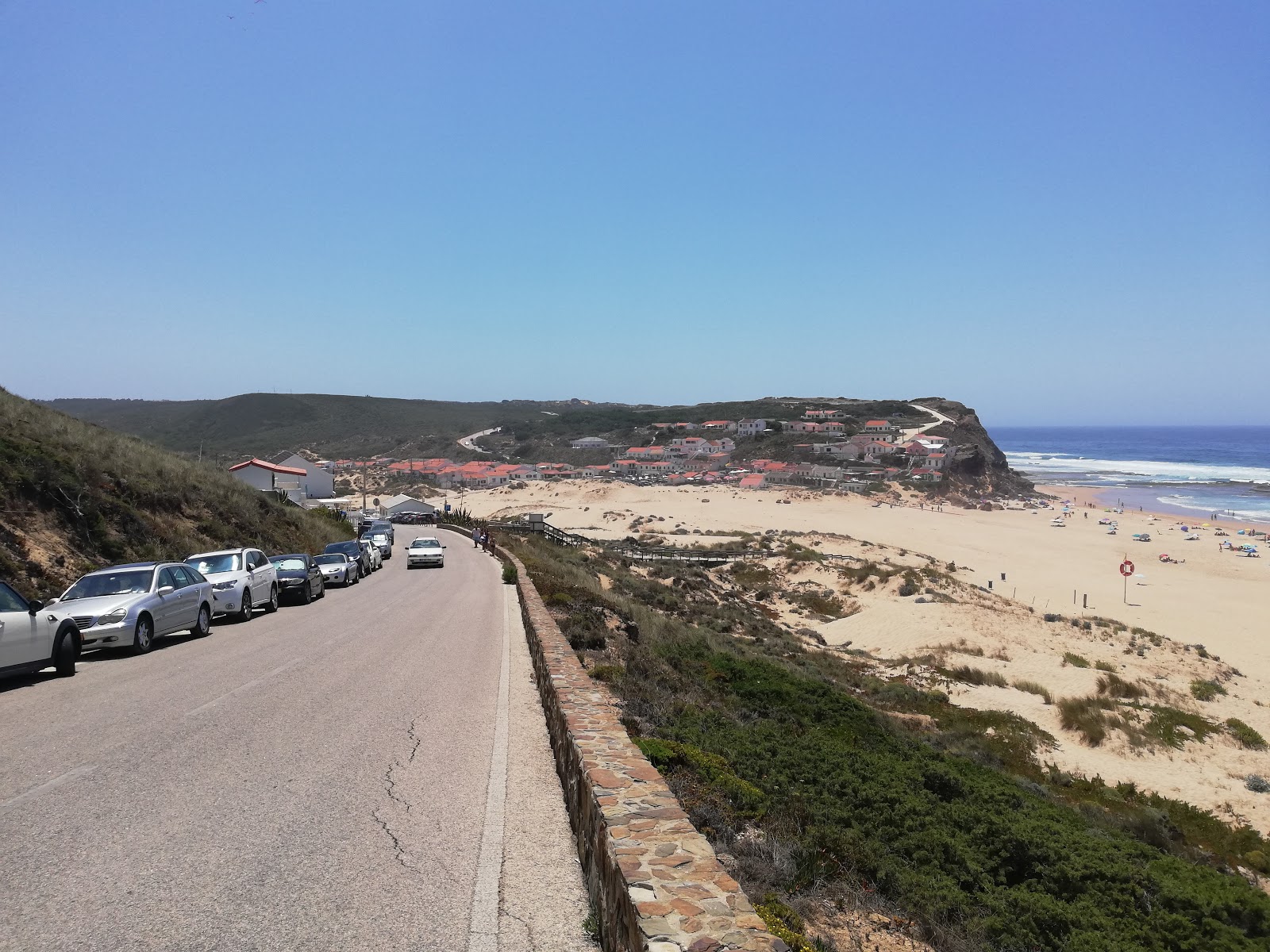 Foto von Praia de Monte Clerigo von Klippen umgeben