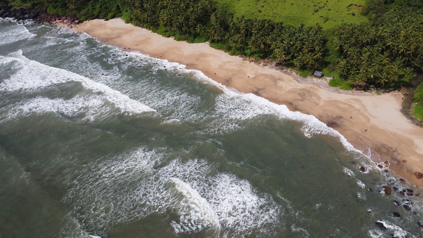 Photo of Canaguinim Beach backed by cliffs