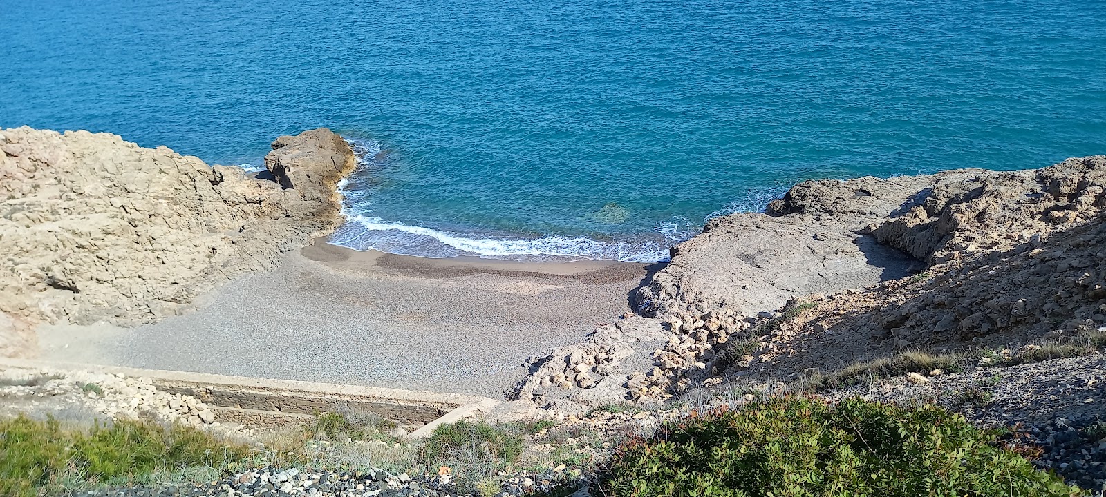 Foto de Cova Del Llop Mari Beach con agua cristalina superficie