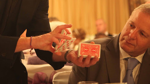 Close-up, sleight of hand magician for hire at weddings and private parties.