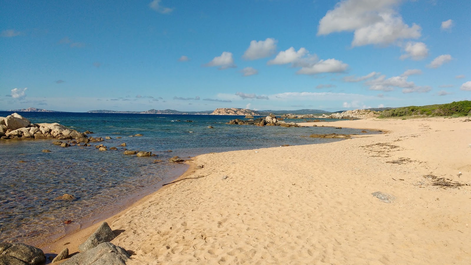 Photo of Spiaggia Rio Li Sardi with brown sand &  rocks surface
