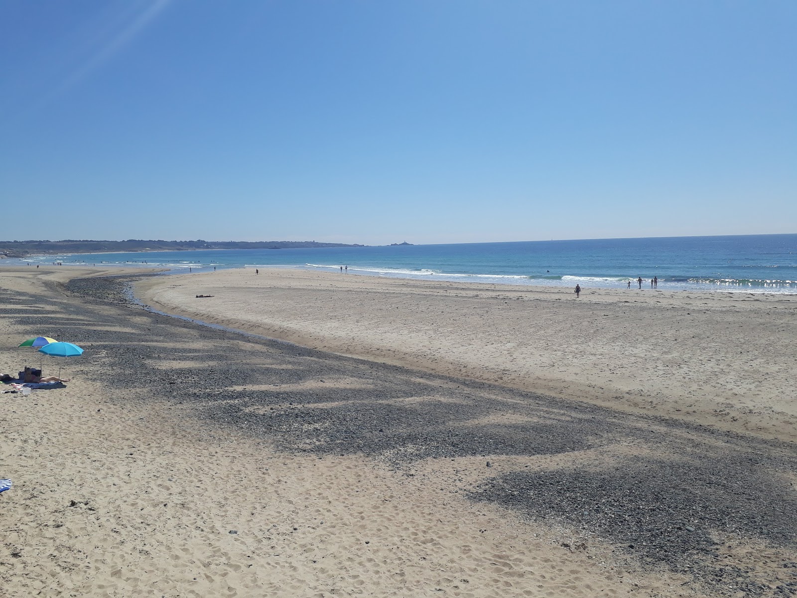Foto di St Ouens Bay con una superficie del sabbia beige e ciottoli