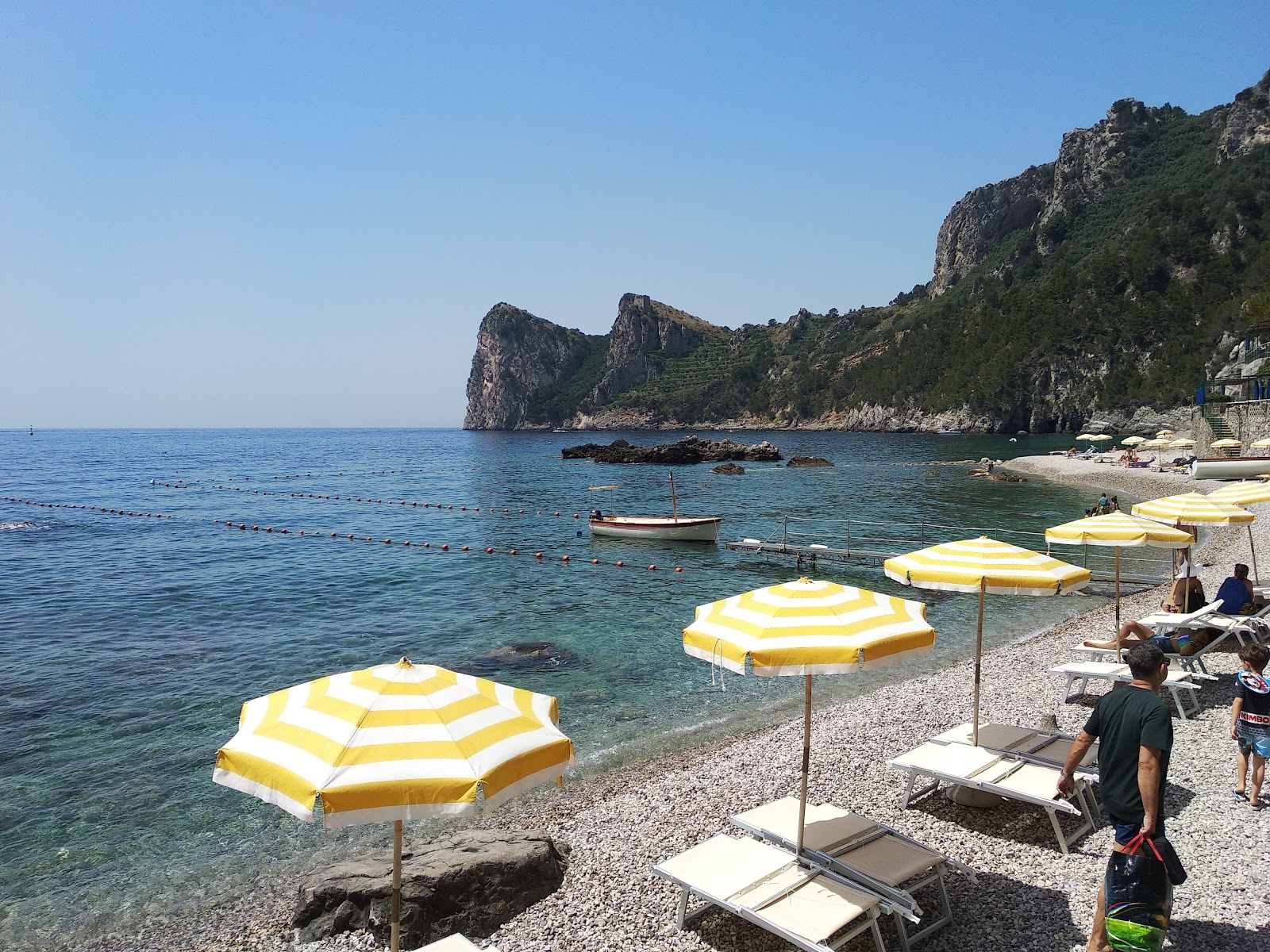 Foto av Spiaggia la Perla med grå fin sten yta