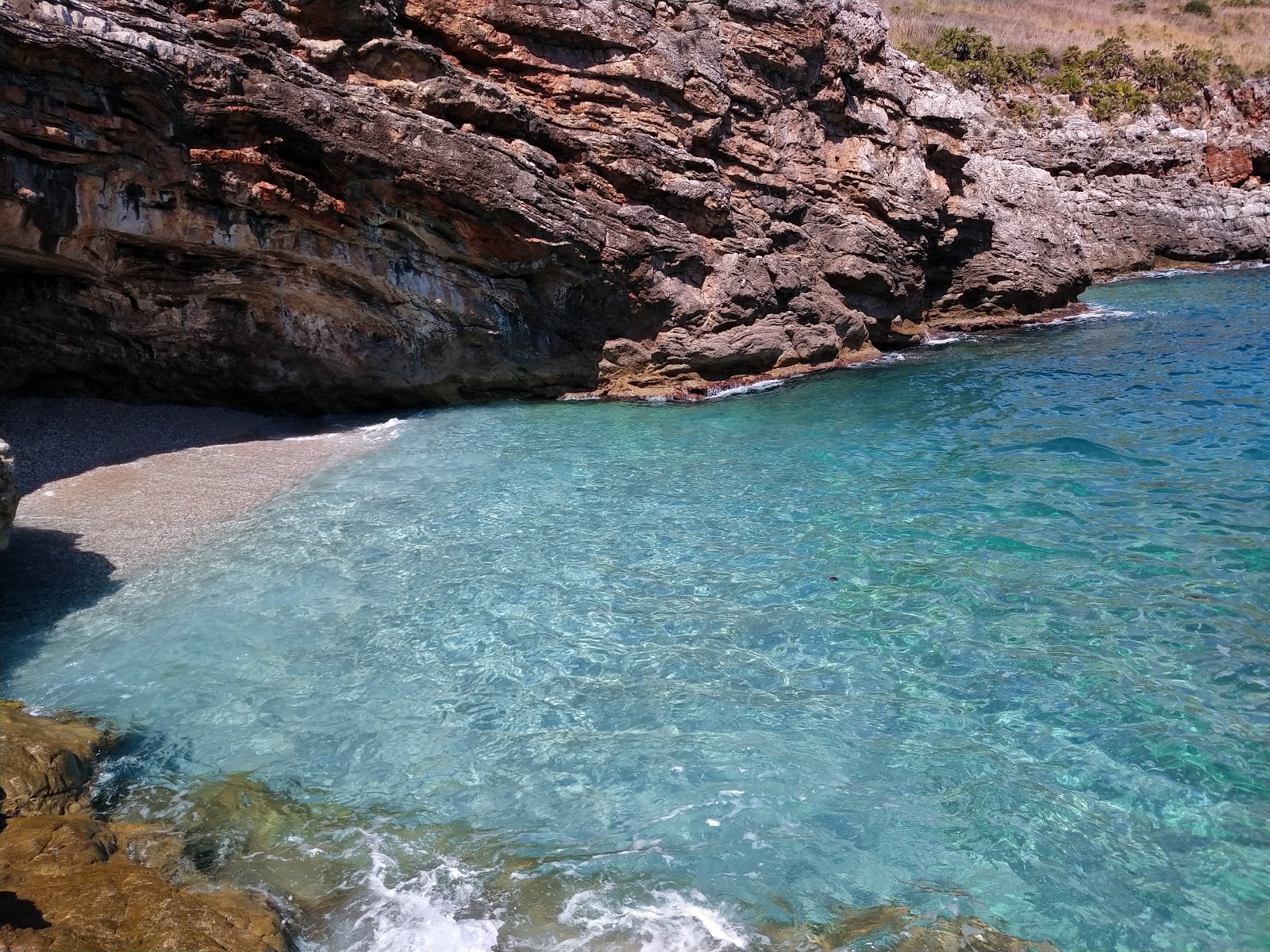 Foto av Cala Marinella och dess vackra landskap