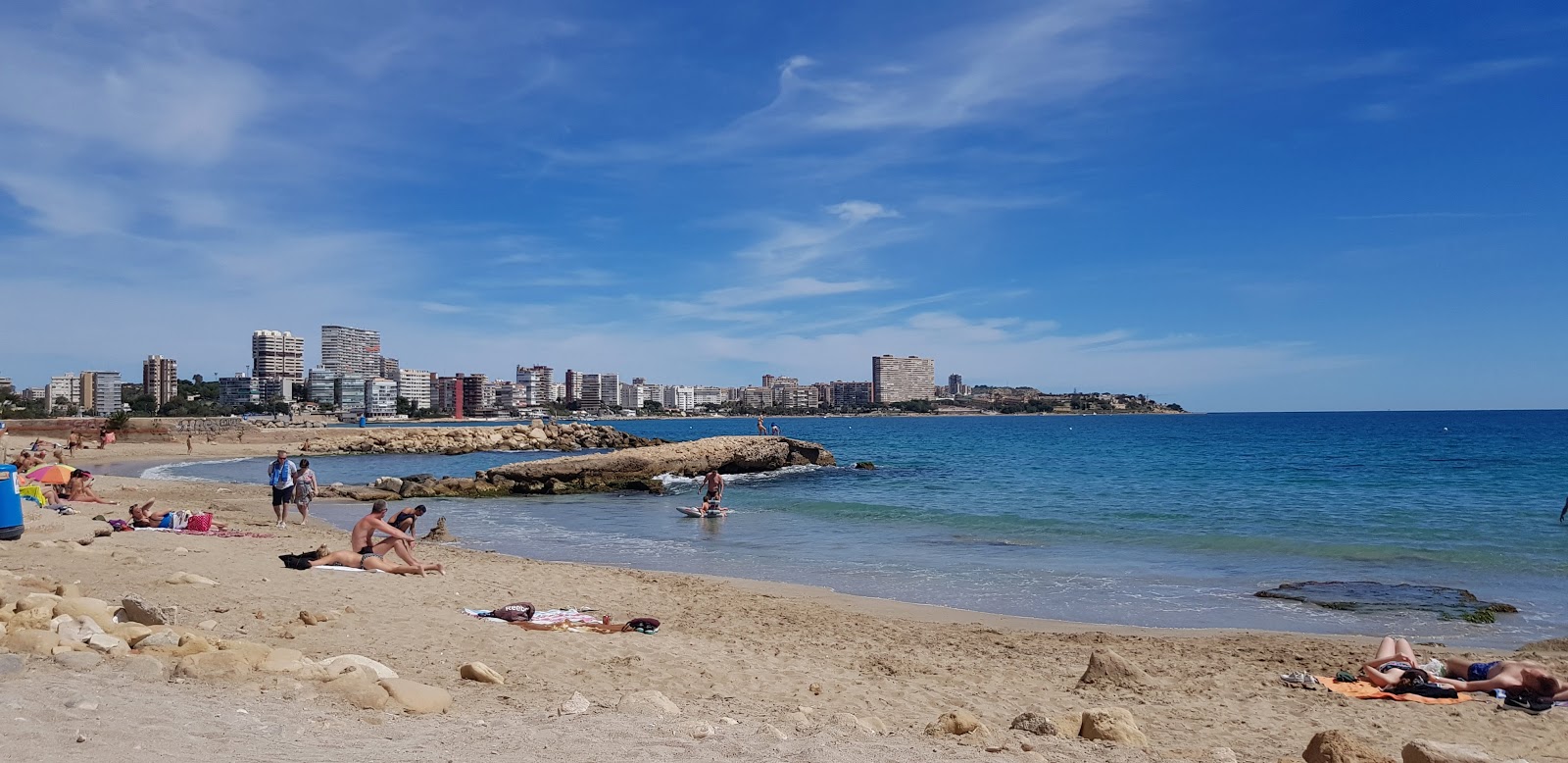 Foto av Calas de Alicante med musta hiekka ja kivi yta