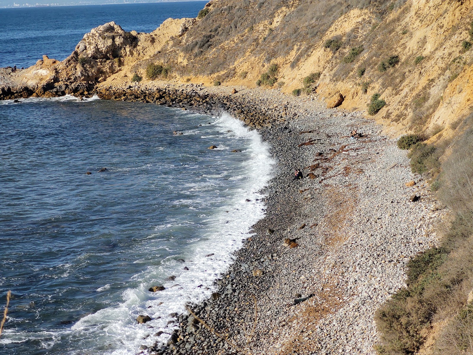 Asiri Rock beach的照片 带有灰色沙和岩石表面