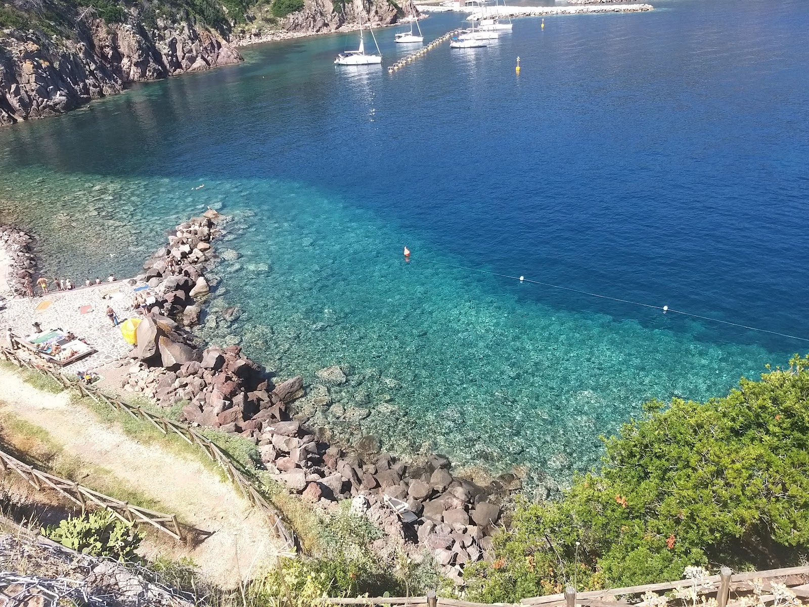 Foto von Spiaggia Cala la Grotta umgeben von Bergen