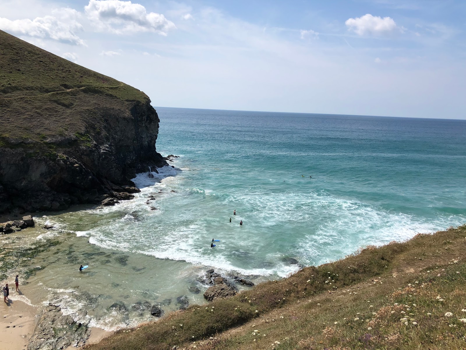 Photo of Chapel Porth beach surrounded by mountains