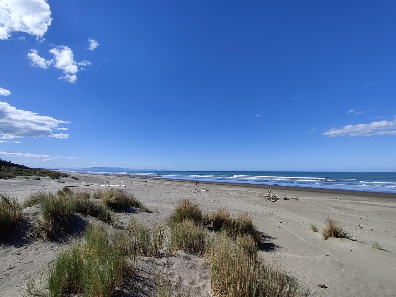 Foto van Woodend Beach met helder zand oppervlakte