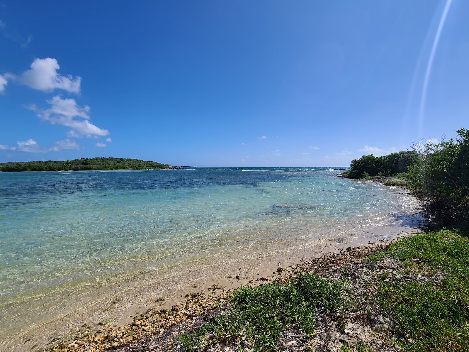 Photo of Blue beach with gray sand &  rocks surface