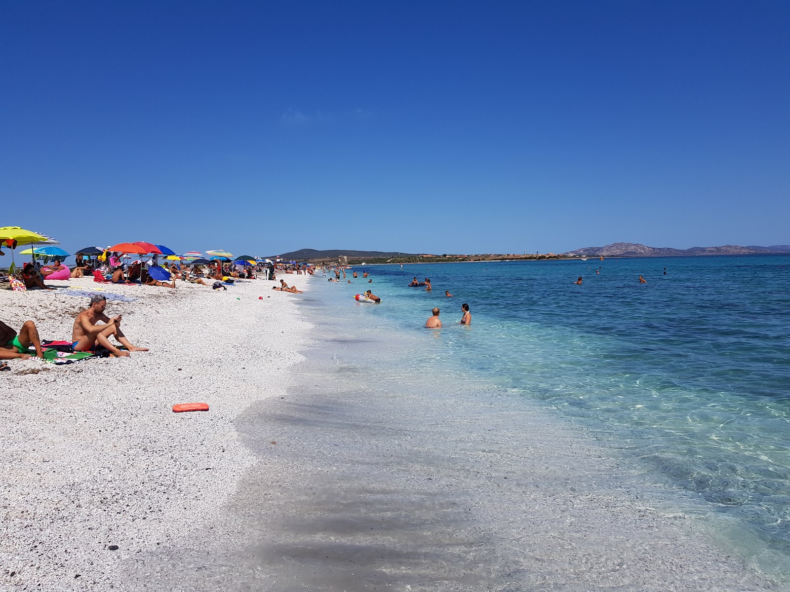 Foto di Spiaggia delle Saline con una superficie del ciottolo fine bianco