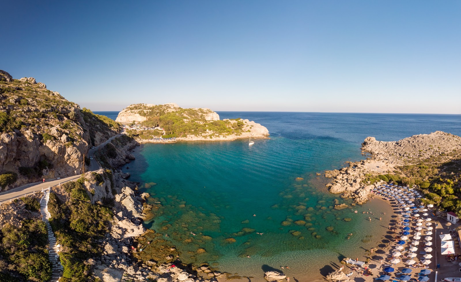 Photo of Anthony Quinn Bay with turquoise pure water surface